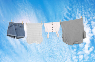Different clothes drying on washing line against blue sky