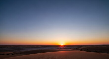 Fototapeta premium Golden Sun Dips Below Horizon Painting Desert Dunes in Warm Hues at Dusk