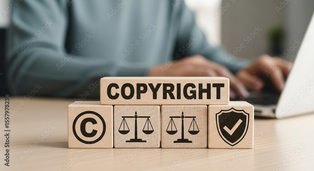 Poster copyright concept with wooden blocks showing symbol scales and shield on a desk with laptop use