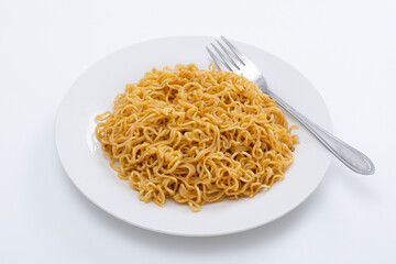 Fried instant noodles with fork on white table