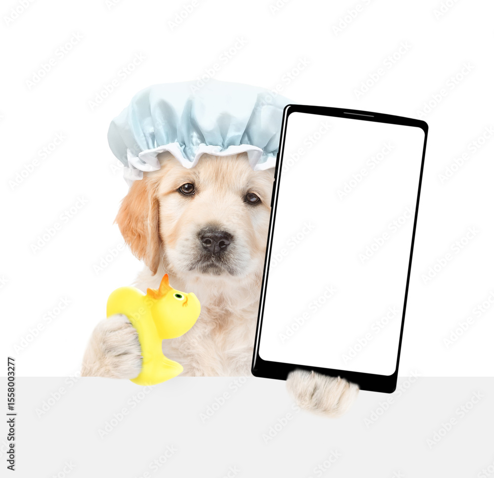 Poster golden retriever puppy wearing shower cap holds rubber suck and big smartphone with white blank scre
