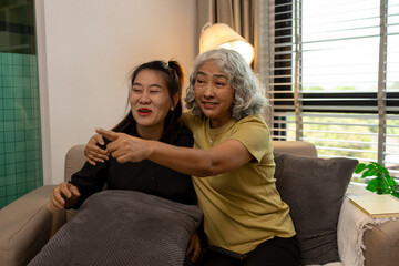 Obraz premium a mother and daughter are spending their free time together at home, the daughter spends his weekend visiting his elderly mother, a family full of love between a mother and daughter