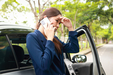Asian woman calls emergency services because her car broke down and was parked on the side of the road. Car accident insurance. Transportation concept.