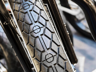 Elegant bicycle tire capturing intricate tread patterns in bright daylight, highlighting design and functionality in urban backdrop