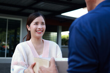 Delivery man in blue shirt holding a box and delivering it to the customer at the doorstep. Transporting goods, parcels.