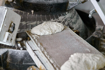 Dough being transported on conveyor belt in a baking facility during production process
