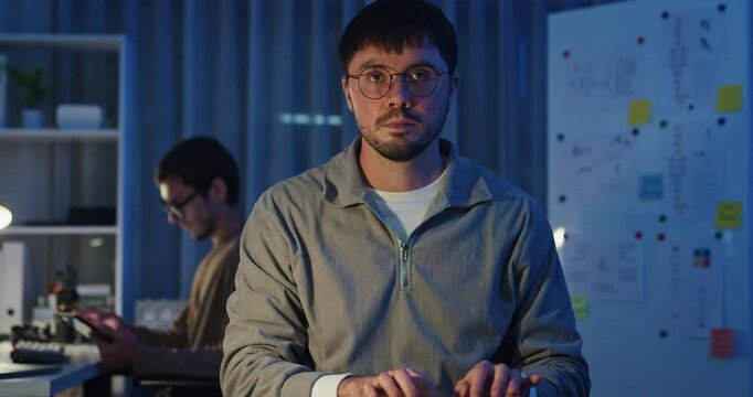 Team adult male freelance developer work late typing write prompt AI bot app program nomad terminal code at office night. Artificial intelligence dashboard, robotics, user interface, machine learning.