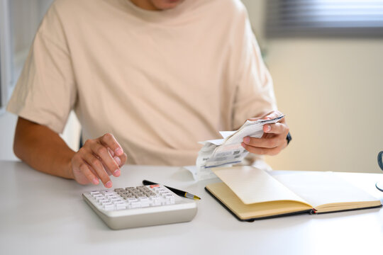 Close up of hands calculating bills and expenses with paper receipts