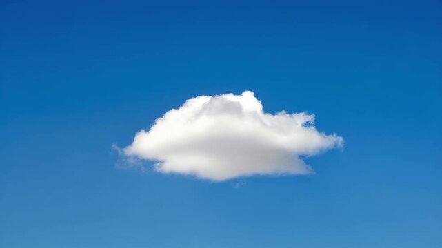 Single fluffy white cloud floating peacefully in the clear blue sky on a bright sunny day, creating a calm, serene scene.