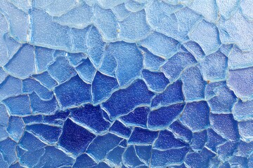 An abstract of a broken blue glass surface, revealing a captivating pattern of cracks and fissures. The varying shades of blue create a stunning visual effect