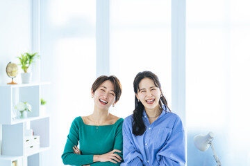 Obraz premium モダンなオフィスで寄り添う二人の女性