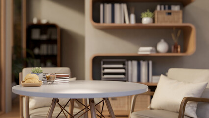 Glass cup of coffee and bread on plate aside book on round wooden table in living room or book cafe