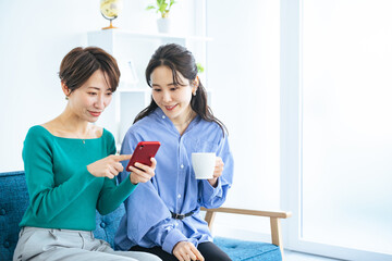 モダンなリビングでスマホを見る二人の女性