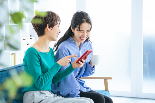 スマホ、スマートフォン、動画、女性、話題、トレンド、口コミ、クチコミ、笑顔、セール、キャンペーン、レディースデイ、アプリ、SNS、ソーシャルメディア、ニュース、メール、検索、メッセージ、ポイント、クーポン、ECサイト、ネットショッピング、通販、二人、会話、話す、相談、ミドルエイジ、女子会、30代、40代、くつろぐ、リラックス、カフェ、おしゃべり、インターネット、オンライン、web、好み、推し活、日