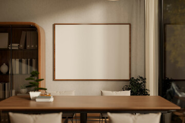 Empty frame on wall aside cabinet and wooden table with bonsai pot and books in living room or cafe.