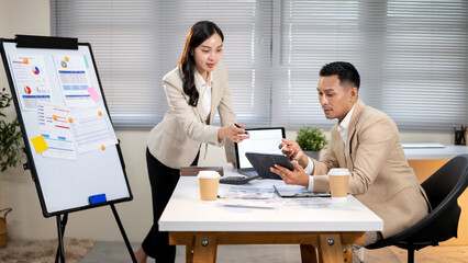 Businesswoman or office worker explaining report on tablet or answer boss's question as pointing pen