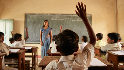 Female teacher assists a diverse group of children learning in a vibrant school classroom