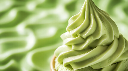 Creamy matcha soft serve ice cream swirled in cone against textured green background