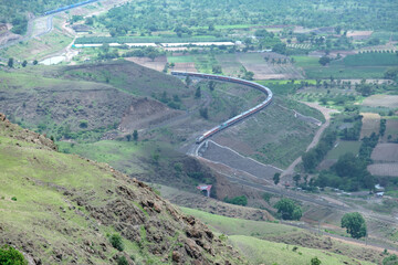 Passenger train hauled by a WAP7 electric locomotive near Pune India.