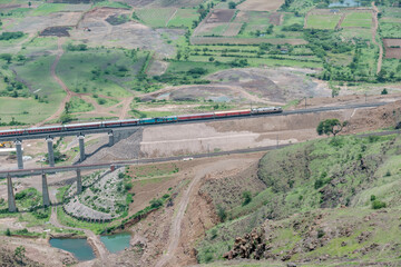 Passenger train hauled by a WAP7 electric locomotive near Pune India.