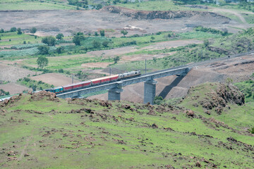 Passenger train hauled by a WAP7 electric locomotive near Pune India.
