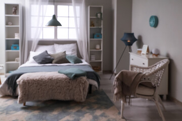 Blurred view of bedroom with big bed and lamps