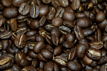 Top view background of aromatic brown coffee beans scattered on the surface.