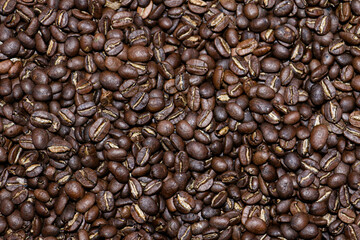 Top view background of aromatic brown coffee beans scattered on the surface.