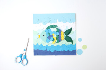 Colorful fish paper cutout surrounded by circles and scissors for preschool curriculum content,...