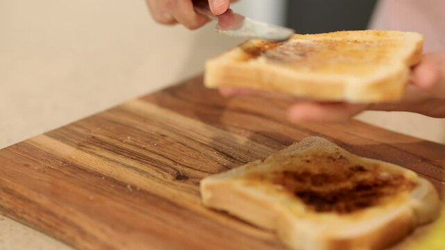 Spreading Vegemite on Bread in a Kitchen Setting