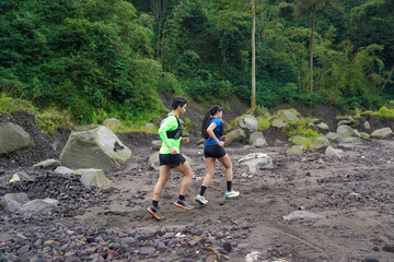 Asian Indonesian couple trail running outdoors, active sustainable lifestyle exercise