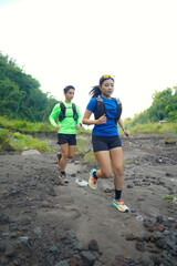 Asian Indonesian couple trail running outdoors, active sustainable lifestyle exercise