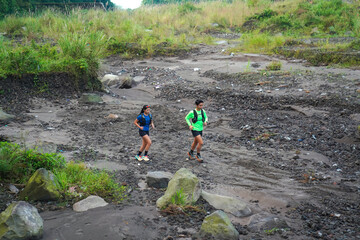Asian Indonesian couple trail running outdoors, active sustainable lifestyle exercise