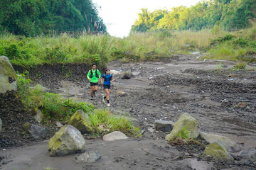 Asian Indonesian couple trail running outdoors, active sustainable lifestyle exercise