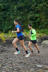 Asian Indonesian couple trail running outdoors, active sustainable lifestyle exercise