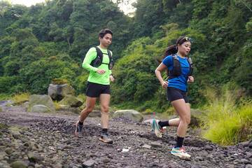 Asian Indonesian couple trail running outdoors, active sustainable lifestyle exercise