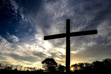 Silhouette of a cross against a vibrant sunset sky. Symbol of faith, hope, and spirituality