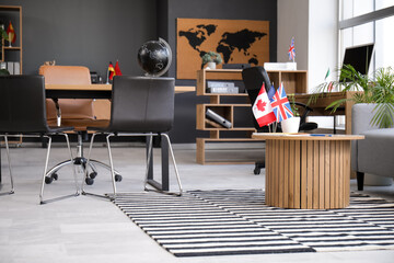 Interior of travel agency with tables and flags