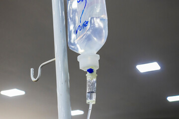 Close-up of an IV drip with visible fluid and bubbles, suggesting a hospital setting. Medical...