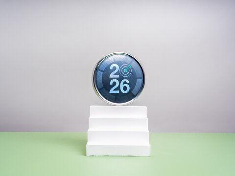 Happy new year 2026 background. 2026 calendar numbers with target icon on round chrome badge on on top of white stairway on green table, white background. Business growth, goal and success concept. - Powered by Adobe