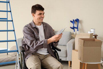 Young man in wheelchair with paint color palettes during repair at home