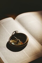 High angle view of pocket watch on open book