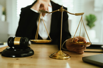 Lawyer sitting at desk in modern office reviewing and signing legal documents related to finance,...