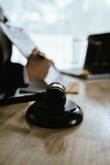 Lawyer sitting at desk in modern office reviewing and signing legal documents related to finance, equity and contractual agreements in business law.