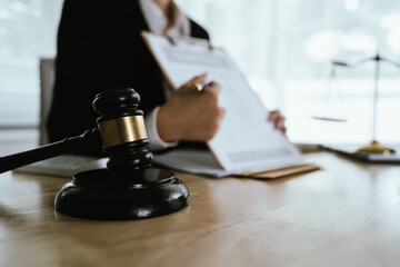 Lawyer sitting at desk in modern office reviewing and signing legal documents related to finance, equity and contractual agreements in business law.