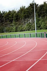 Fototapete Curved red track is winding in flat design with white lanes, railing, hedge and light pole © vectorfusionart