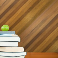 Green apple on pile of books