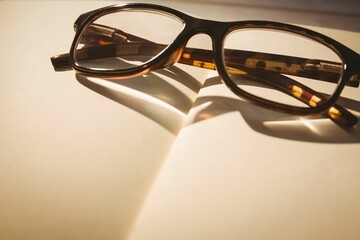 Plastic eyeglasses on blank book