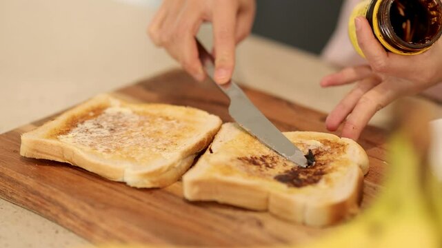 Spreading Vegemite on Toast in a Kitchen
