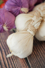 Garlic bulbs tied together on wooden table surface